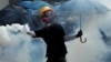 Hong Kong --An anti-government protester holding an umbrella throws a tear gas canister during a demonstration at Causeway Bay district in Hong Kong, China September 29, 2019